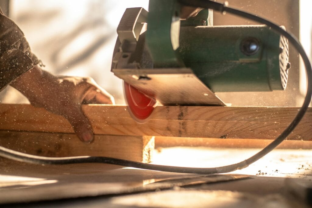 Circular saw cutting a wooden plank with visible dust particles, highlighting craftsmanship.